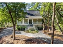Charming home exterior featuring a welcoming front porch and lush landscaping at 3052 Seabrook Island Rd, Seabrook Island, SC 29455