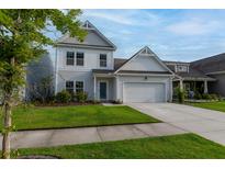 Charming two-story home with an attached two-car garage, well-manicured lawn, and lovely landscaping at 408 Fox Sparrow Ct, Summerville, SC 29486