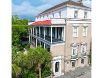 Charming multi-story home featuring double balconies, classic architecture, and mature landscaping at 81 Rutledge Ave, Charleston, SC 29401