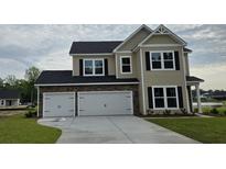 Beautiful two-story home with stone accents, a spacious three-car garage, and a well-manicured lawn at 114 Captains Creek Ln, Ridgeville, SC 29472
