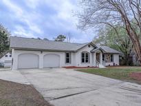 Charming single-story home with a two-car garage and a well-maintained front yard, showcasing curb appeal at 132 Tranquil Ln, Ladson, SC 29456