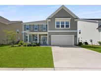Charming two-story home with a manicured lawn, neutral siding, and inviting front porch at 133 Headwater Dr, Summerville, SC 29486