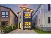Modern home featuring unique design, multiple windows, a concrete driveway, and stylish exterior lighting at 14 F St # B, Charleston, SC 29403