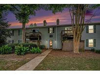 A charming two-story exterior view showcasing a well-maintained facade and landscaped front yard at 1402 Camp Rd # 9G, Charleston, SC 29412