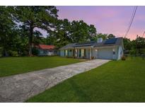 Charming single-story home featuring solar panels and a well-manicured lawn at 171 N Main St, Ridgeville, SC 29472
