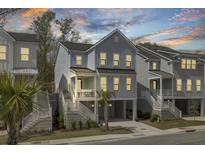 Charming two-story coastal home with a covered porch, white railings, and a convenient ground-level garage at 1821 Mead Ln, Johns Island, SC 29455