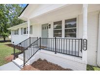 Inviting front porch features black railings and updated white brick, creating a welcoming entrance at 209 Pineview Dr, Goose Creek, SC 29445