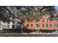 Brick condo building facade with mature trees on a sunny day at 21 George St # 102, Charleston, SC 29401