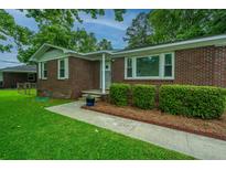 Charming single-story brick home with lush green lawn and neatly trimmed hedges at 2567 Mona Ave, Charleston, SC 29414