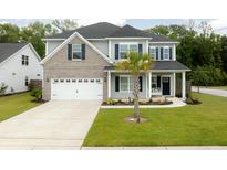 Charming two-story home featuring a two-car garage, landscaped yard and welcoming front porch at 2802 Cavalcade Cir, Johns Island, SC 29455