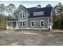 Two-story home featuring sage green siding, white trim, and charming dark shutters at 3006 Sweetwater Ln, Awendaw, SC 29429