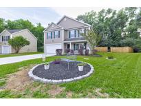 Charming two-story home with green shutters, a manicured lawn, and a decorative front yard at 3009 Mapleleaf Dr, Moncks Corner, SC 29461