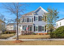 Charming two-story home featuring a manicured lawn and classic American architecture on a sunny day at 308 Oak Park St, Summerville, SC 29486