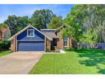 Charming two-story home features a two-car garage and a well-manicured lawn surrounded by mature trees at 310 Christiee Ct, North Charleston, SC 29418