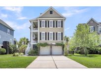 Beautiful two-story home featuring double garage, charming balconies, and a well-manicured lawn at 327 Megans Bay Ln, Charleston, SC 29492