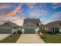 Charming single-Gathering home with a two-car garage and well-manicured lawn under a dramatic colorful dusk sky at 350 Dahlia Row Dr, Summerville, SC 29486