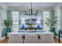 Stylish dining room features large windows, a modern chandelier, and seating for six at 3805 Adrian Way, Mount Pleasant, SC 29466