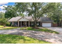Charming brick home with a large front yard, mature trees and a circular driveway provides shade and curb appeal at 44 S Basilica Ave, Hanahan, SC 29410
