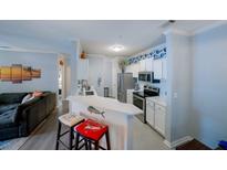 Charming kitchen features white cabinets, stainless steel appliances, barstool seating, and blue accents at 45 Sycamore Ave # 611, Charleston, SC 29407