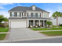 Charming two-story home with a well-manicured lawn, a two car garage and inviting front porch at 451 Spectrum Rd, Summerville, SC 29486