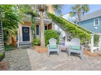 Inviting front yard with brick, exterior stairs, seating, and lush greenery offers a warm welcome at 5 1/2 Kracke St # A, Charleston, SC 29403