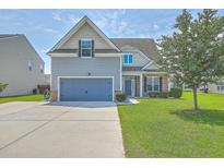Charming two-story home with a well-manicured lawn, blue garage door, and inviting curb appeal at 575 Rosings Dr, Summerville, SC 29486