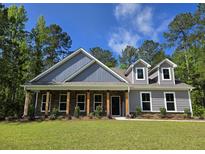 Charming single-Gathering home with a welcoming front porch and craftsman-style details in a tranquil, wooded setting at 6081 Sourwood Trl, Ridgeville, SC 29472