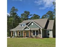 Charming craftsman-style home with stone accents and a well-manicured lawn at 6105 Sourwood Trl, Ridgeville, SC 29472