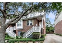 Charming brick townhome with white stairs, lush landscaping, and mature trees, offering curb appeal at 622 Windermere Blvd # D, Charleston, SC 29407