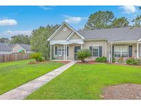 Charming single-story home features a cozy front porch and well-manicured lawn at 7300 Suncatcher Dr, Hanahan, SC 29410