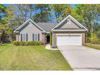 Charming single-story home featuring well-kept lawn, neutral siding, brick accents, and an attached two-car garage at 1179 Holly Bend Dr, Mount Pleasant, SC 29466
