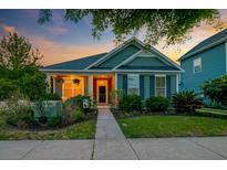 Charming home featuring manicured lawn, inviting front porch, and lush landscaping at 1589 Seabago Dr, Charleston, SC 29414