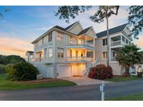 Charming three-story home featuring double balconies, an attached garage, and beautifully landscaped surroundings at 1647 Marsh Harbor Ln, Mount Pleasant, SC 29464