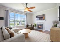 Cozy living room featuring a fireplace, ceiling fan, and a large window with a waterfront view at 1713 Pimlico Blvd, Moncks Corner, SC 29461