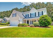 Charming two-story home featuring a well-manicured lawn, attached garage, and neutral siding at 195 Highwoods Plantation Ave, Summerville, SC 29485