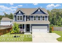 Charming two-story home features a manicured lawn, blue siding, and a two-car garage at 203 Plowden Mill Ct, Summerville, SC 29485