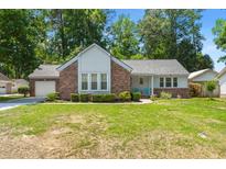 Charming single-Gathering home with brick and siding exterior, lush lawn, and attached garage at 204 Runnymede Ln, Summerville, SC 29485