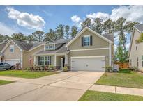 Charming home with a manicured lawn, flower beds, and a two-car garage at 227 Spectrum Rd, Summerville, SC 29486