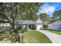 Charming single-story home featuring a well-manicured lawn and mature landscaping at 2418 Castlereagh Rd, Charleston, SC 29414