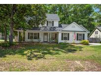 Charming two-story home with a landscaped yard, inviting front porch, and classic black shutters at 2916 Shadow Ln, North Charleston, SC 29406
