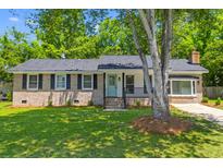 Charming brick home featuring black shutters, a teal front door, and a well-manicured lawn at 300 Oklahoma Pl, Ladson, SC 29456