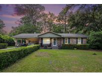 Charming brick home featuring a well-maintained lawn and lush landscaping at 308 Ashley Dr, Summerville, SC 29485