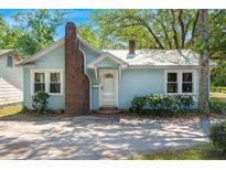 Charming light blue one-story home with brick chimney and well-manicured landscaping in the front yard at 309 Padgett Loop, Walterboro, SC 29488