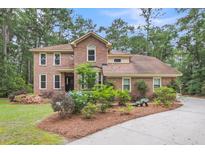 Charming brick two-story home featuring a well-manicured lawn and lush landscaping at 320 Compton Xing, Summerville, SC 29485