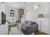 Cozy living room with a grey sectional sofa, exposed brick, and a window for natural light at 33 Pitt St # 3, Charleston, SC 29401