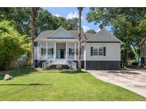 Charming two-story home featuring a welcoming porch, complemented by palm trees and a well-maintained lawn at 3872 James Bay Road Rd, Johns Island, SC 29455
