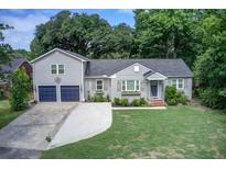 Charming home featuring a well-manicured lawn, an attached two-car garage, and tasteful exterior shutters at 5043 Victoria Ave, North Charleston, SC 29405