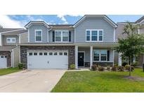 Charming two-story home featuring gray siding, stone accents, and a well-manicured lawn at 5138 Preserve Blvd, Ladson, SC 29456