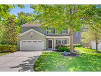 Charming two-story home featuring a manicured lawn, attached garage, and welcoming front porch at 5433 Falling Tide, North Charleston, SC 29420