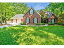 Charming two-story brick home with a well-manicured lawn, mature trees and a three-car garage at 69 King Charles Cir, Summerville, SC 29485